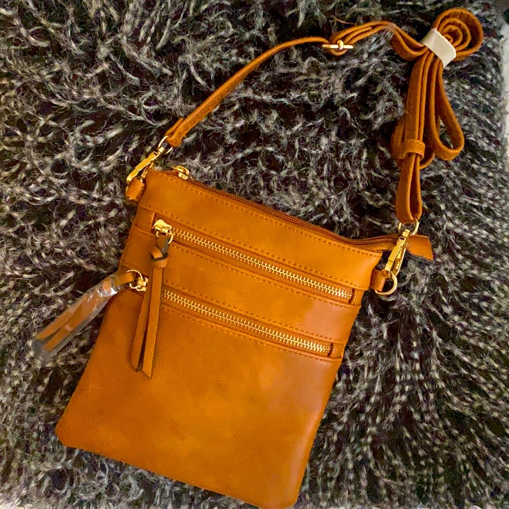 NEW, still in packaging, tan, crossbody purse with gold zippers